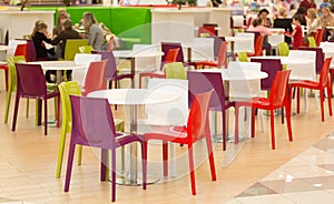 Public dining area with colourul plastic chairs and tables