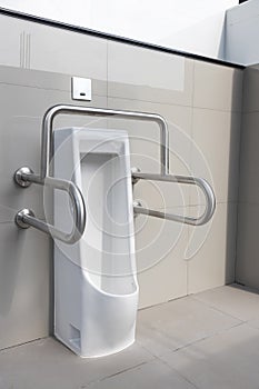 Public disabled toilet in a large building. Modern restroom for disabled people. Inside disable toilet or elderly people. Handrail
