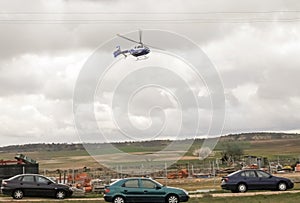 Public emergency service helicopter in the air transporting a seriously injured person from a traffic accident.