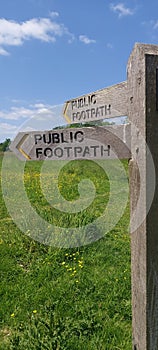 Public footpath direction sign in field.