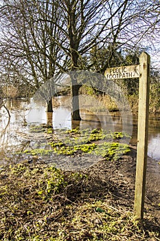 Public footpath sign, with flooded pathway