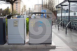 Public garbage bin with waste separation on a city street filled with garbage