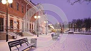 public garden on Sovetskaya emb in Pskov. Winter evening, snowfall, benches