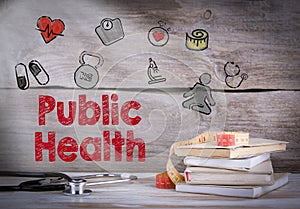 Public Health. Stack of books and a stethoscope on a wooden background