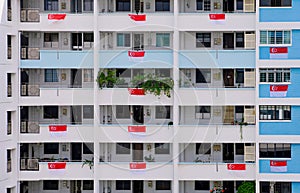 Public housing HDB flats in heartland neighbourhood, Singapore flags hung over the balconies to welcome National Day in August