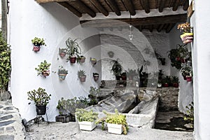 Public laundry in the Alpujarra with a roof or tinao with wooden beams and with many pots hanging on the wall and