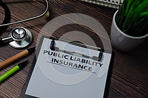 Public Liability Insurance write on paperwork isolated on wooden table