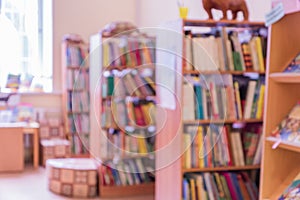 Public library for children defocused intereor. shelving with books