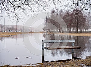 Public Park and Bench on the Water. Early Spring Time. Lithuania, Siauliai.