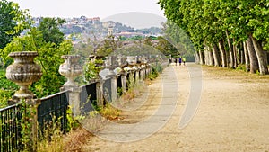 A public park walk along the Tagus River and people doing sports in the distance