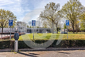 Public parking lot with spaces for handicap and charging station for electric cars