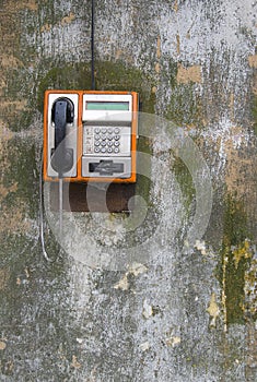 Public phone on grunge wall