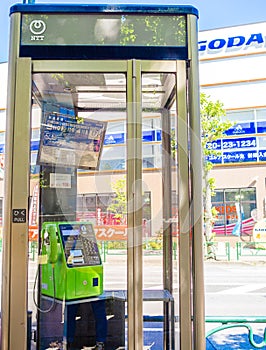 Public phone in Osaka, Japan. Blurry phone through the glass