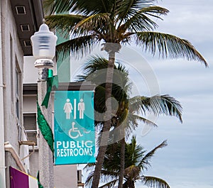 Public restroom sign with palm trees