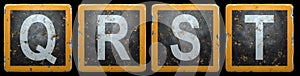 Public road sign orange and black color with a capital set of letters Q, R, S, T in the center isolated on black