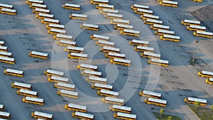 Public school bus parking lot with many yellow buses parked in rows. American education system transportation