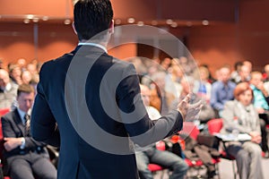 Public speaker giving talk at business event.