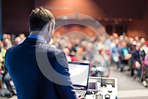 Public speaker giving talk at business event.