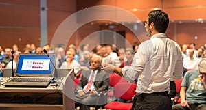 Public speaker giving talk at Business Event.