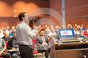 Public speaker giving talk at Business Event.