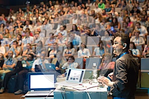 Public speaker giving talk at Business Event.