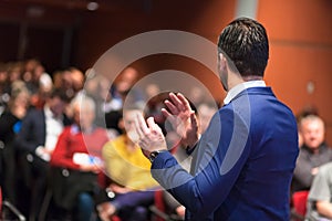 Public speaker giving talk at Business Event.