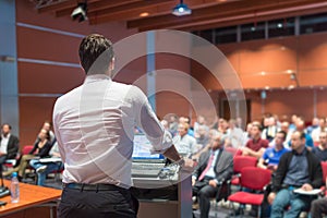 Public speaker giving talk at Business Event.