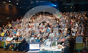 Public speaker giving talk at Business Event.