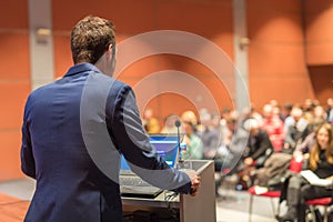 Public speaker giving talk at Business Event.