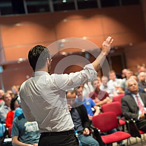 Public speaker giving talk at Business Event.