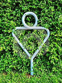 Public toilet graphic sign, Male rest room outdoor symbol made from round steel pipe post with green tree background