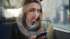 Public transport. Woman in tram using smartphone. Slow motion