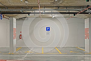 Public underground garage interior with parking spaces for disabled people