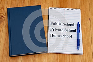 Public vs private vs homeschool schools with retro old blue book with notepad and pen