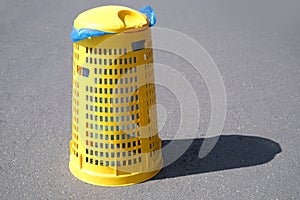 public yellow trash can in Park in Germany, garbage container stands on the pavement, garbage collection in designated place,