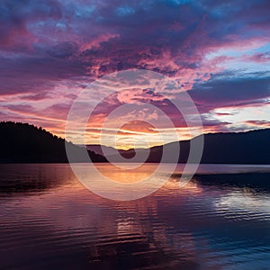 Publish Breathtaking sunset paints the sky with vibrant colors over the lake