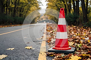 Publish Construction cone on road in autumn, seasonal road safety