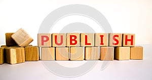 Publish symbol. The concept word Publish on wooden cubes. Beautiful white table, white background, copy space. Business publish