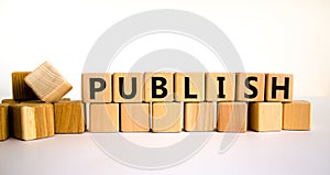 Publish symbol. The concept word Publish on wooden cubes. Beautiful white table, white background, copy space. Business publish