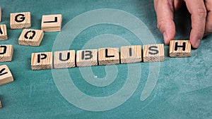 Publish. Wooden alphabet letters on a green blackboard background