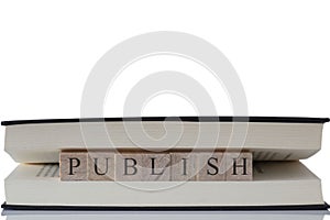 Publish written on wooden blocks inside a book isolated on a white background