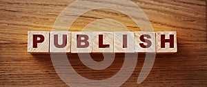 Publish written on a wooden cube on a wood desk. Publishing news concept