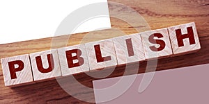 Publish written on a wooden cube on a wood desk. Publishing news concept