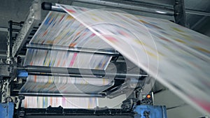 Publishing house unit with paper rolling through the machine. Printing newspapers in typography.