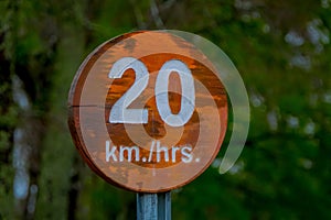 PUCON, CHILE - SEPTEMBER, 23, 2018: Close up of wooden informative sign of 20 km hrs inside of the Pucon recreative photo