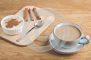 pudding with cinnamon on a wooden tray and a cup of coffee/breakfast with pudding with cinnamon on a wooden tray and a cup of