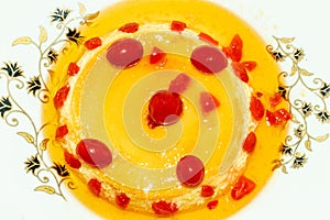 Pudding made with egg milk and sugar and served topped with red cherry fruit