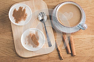 Puddings with cinnamon in a white bowl and a cup of coffee/puddings with cinnamon in a white bowl and a cup of coffee on a wooden