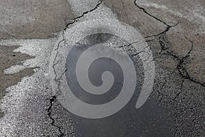 Puddle on asphalt alike a human figure with halo.