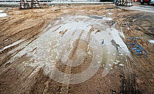 Puddle and mud with truck wheel track at construction site in rainy day